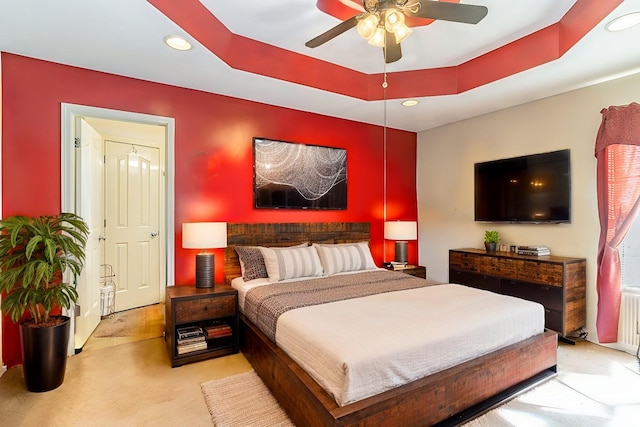 bedroom featuring ceiling fan, a tray ceiling, light colored carpet, and recessed lighting