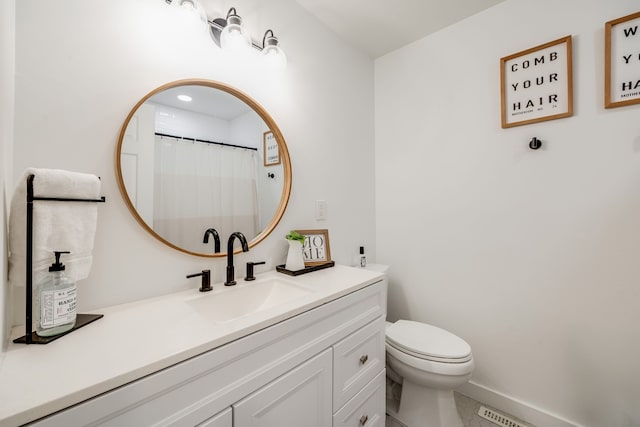 bathroom with tile patterned flooring, vanity, and toilet