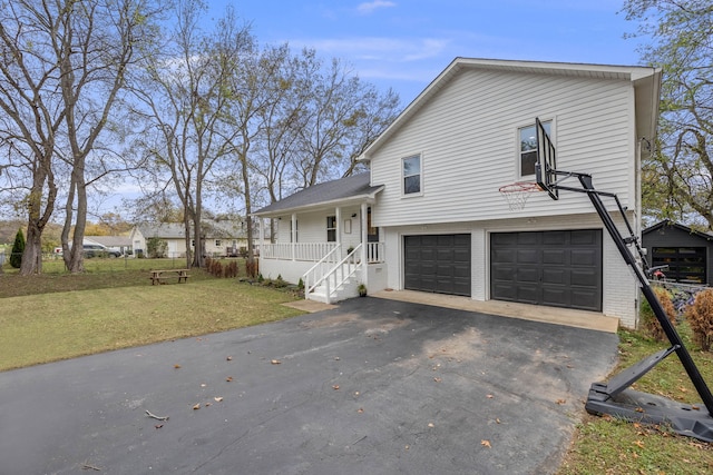 view of front of home featuring a garage, a front yard, and a porch