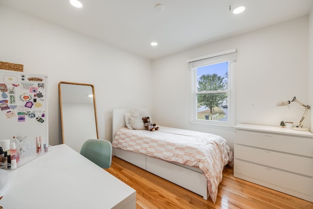 bedroom with white refrigerator and light wood-type flooring