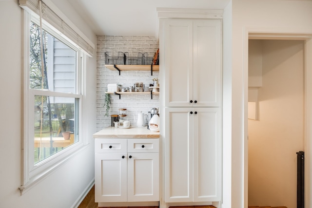 bar with white cabinets, plenty of natural light, and tasteful backsplash