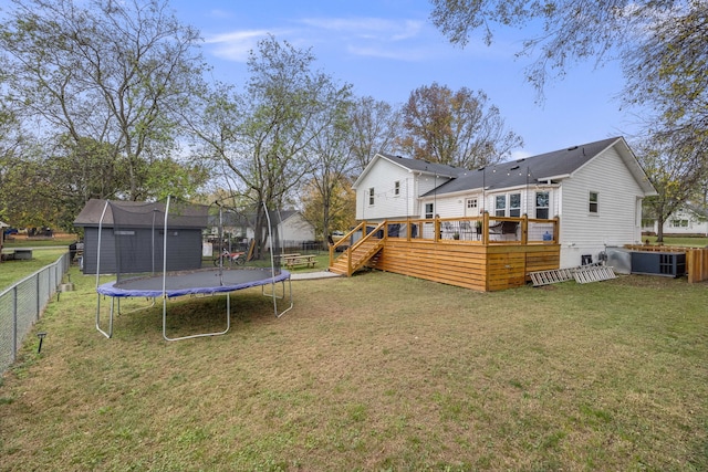 view of yard featuring a wooden deck and a trampoline