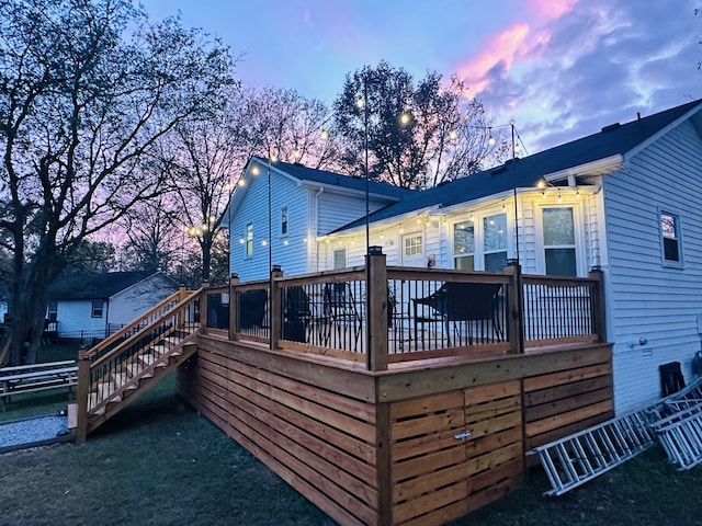 back house at dusk featuring a deck