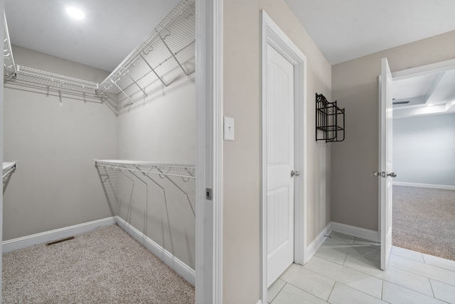 spacious closet featuring light colored carpet