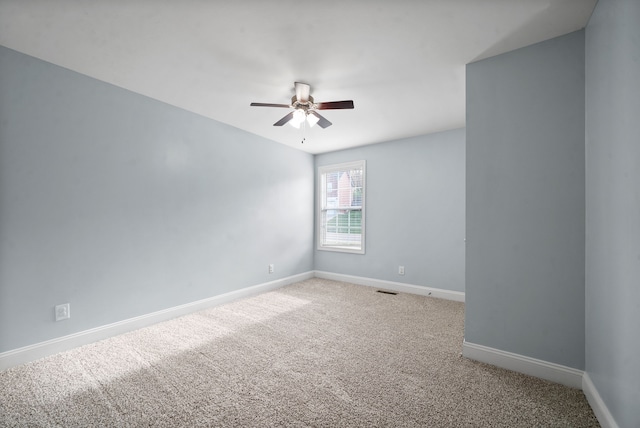 carpeted spare room featuring ceiling fan