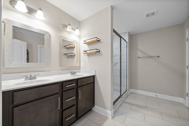 bathroom featuring tile patterned flooring, an enclosed shower, and vanity