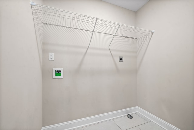 clothes washing area featuring light tile patterned floors and electric dryer hookup