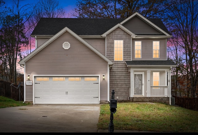 view of front property with a garage, central AC, and a yard