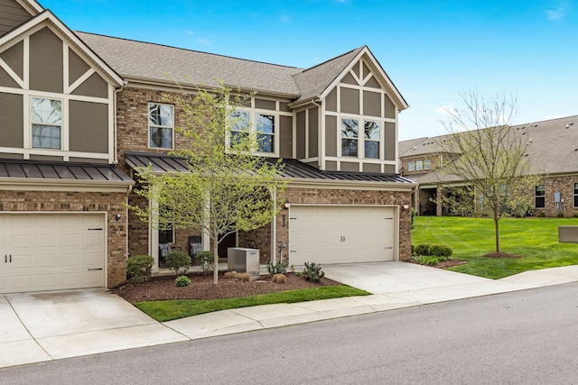 english style home featuring a garage and a front yard