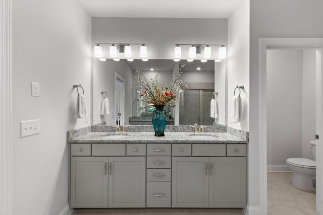 bathroom with toilet, vanity, an enclosed shower, and tile patterned floors