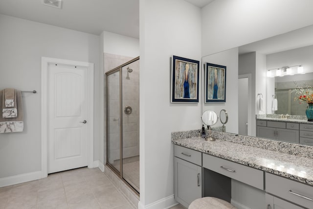 bathroom featuring tile patterned flooring, an enclosed shower, and vanity