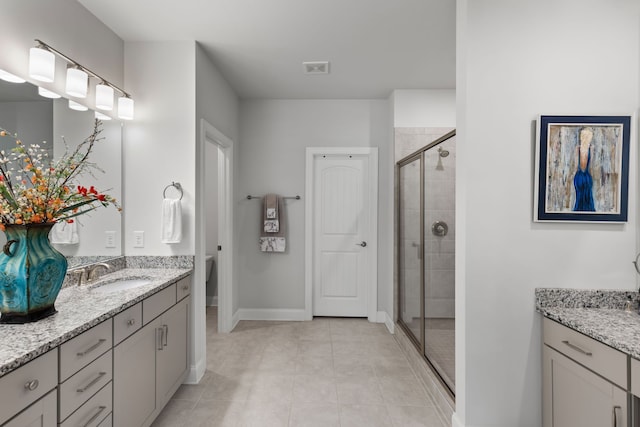 bathroom featuring walk in shower, vanity, tile patterned floors, and toilet