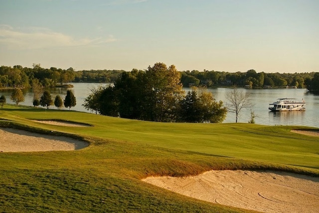 view of property's community with a water view and a lawn