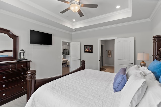 bedroom with ornamental molding, light hardwood / wood-style flooring, ceiling fan, and a tray ceiling