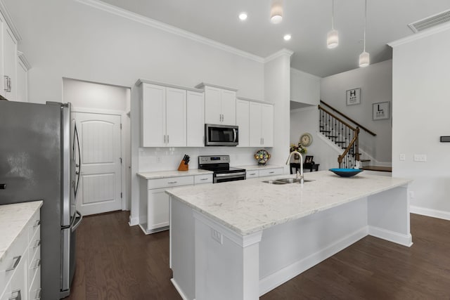 kitchen with white cabinetry, a center island with sink, stainless steel appliances, and sink