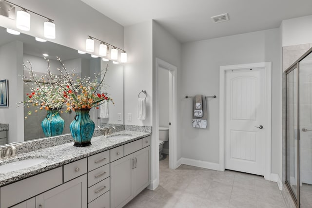 bathroom featuring tile patterned flooring, an enclosed shower, vanity, and toilet