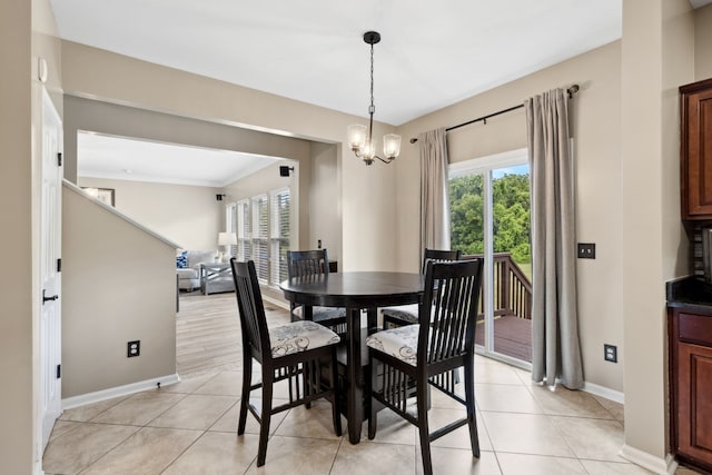 dining room with a chandelier, light tile patterned flooring, and crown molding