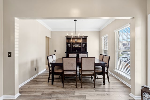 dining area with ornamental molding, light hardwood / wood-style flooring, and a notable chandelier