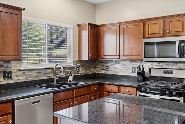 kitchen with dark stone counters, sink, appliances with stainless steel finishes, and tasteful backsplash