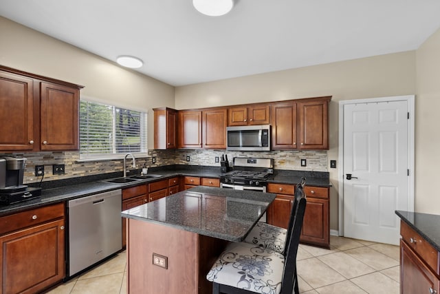 kitchen featuring stainless steel appliances, sink, decorative backsplash, and a center island