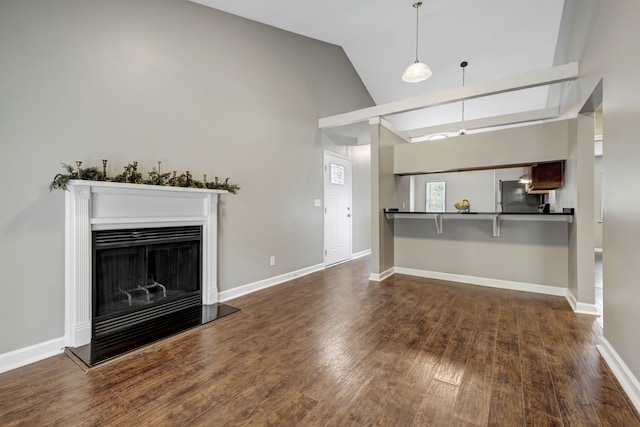 unfurnished living room with dark wood-type flooring and high vaulted ceiling