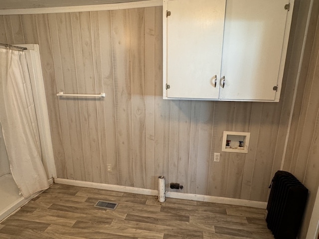 washroom with wood walls, washer hookup, dark hardwood / wood-style floors, and radiator