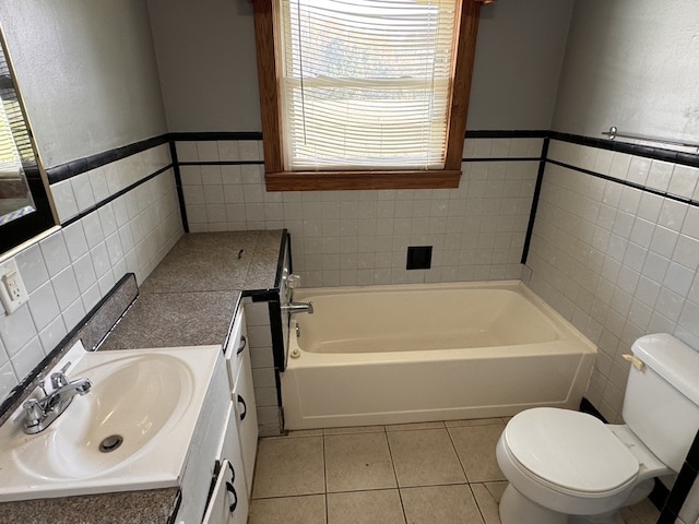 bathroom featuring toilet, a tub, tile walls, tile patterned flooring, and vanity