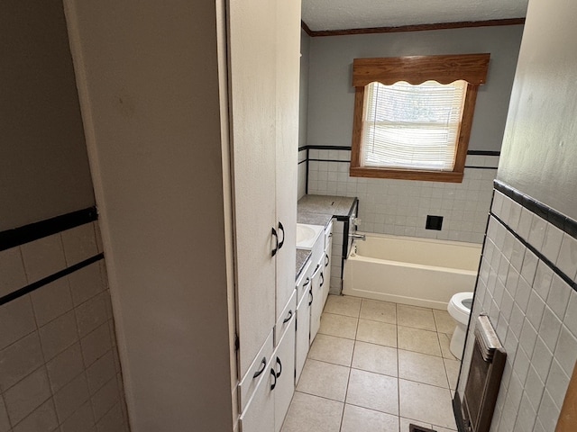 bathroom with tile walls, tile patterned flooring, a bathtub, and crown molding