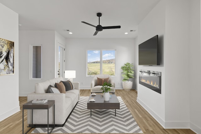 living room with ceiling fan and light wood-type flooring