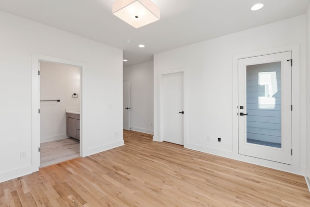 interior space with ensuite bath and light hardwood / wood-style floors