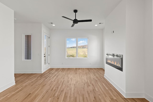 unfurnished living room with light hardwood / wood-style flooring and ceiling fan