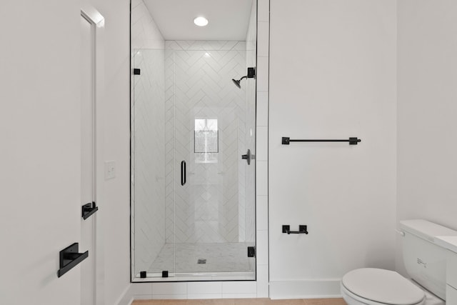 bathroom featuring tile patterned flooring, toilet, and walk in shower