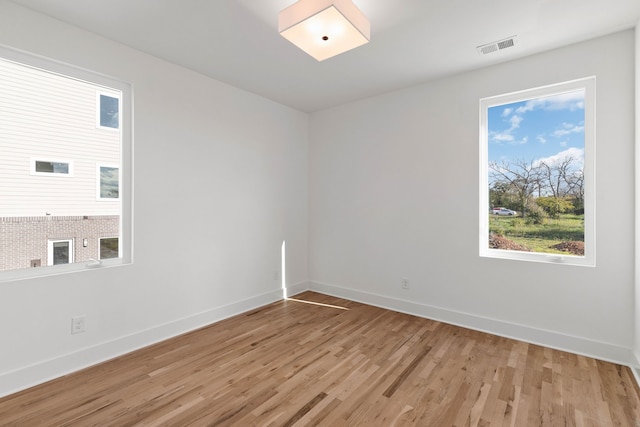 unfurnished room with plenty of natural light and light hardwood / wood-style flooring