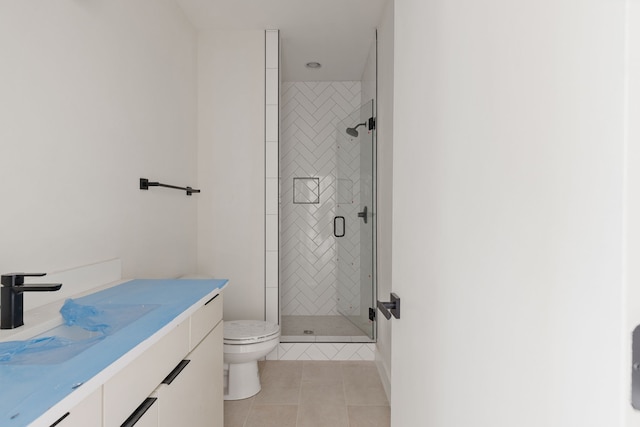 bathroom with vanity, a shower with shower door, tile patterned floors, and toilet