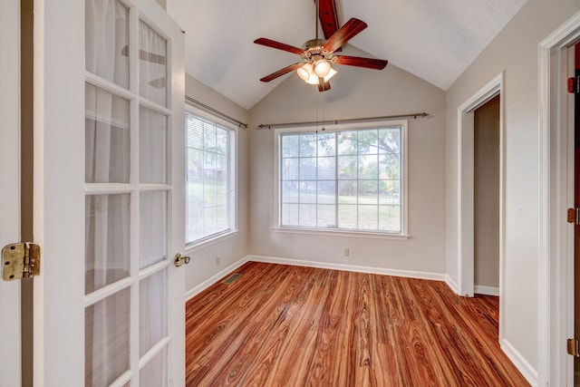 unfurnished room with light hardwood / wood-style flooring, a textured ceiling, ceiling fan, and vaulted ceiling