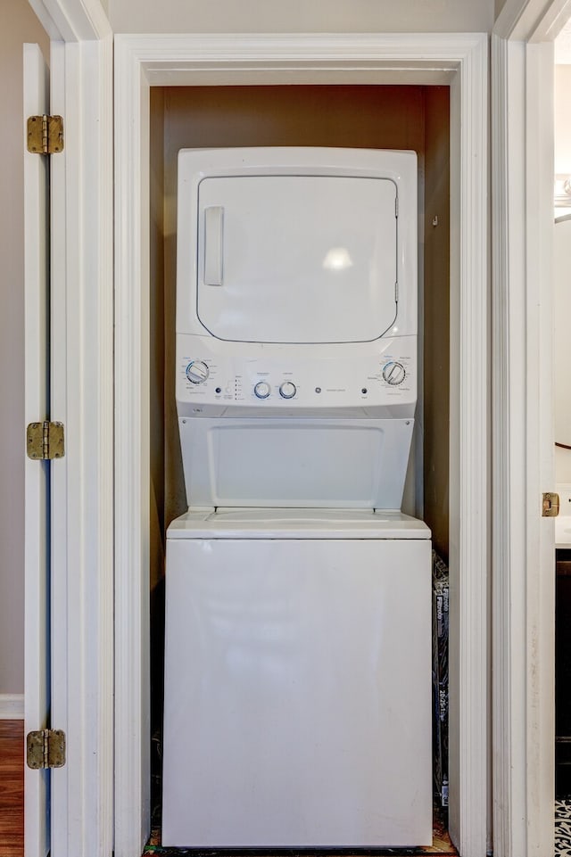 washroom featuring wood-type flooring and stacked washer and clothes dryer