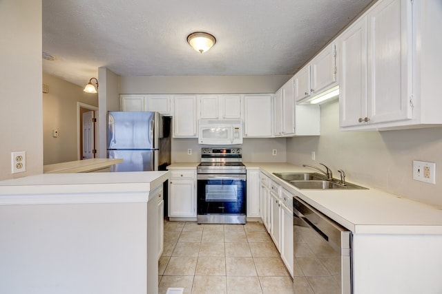 kitchen with stainless steel appliances, white cabinets, kitchen peninsula, a textured ceiling, and sink