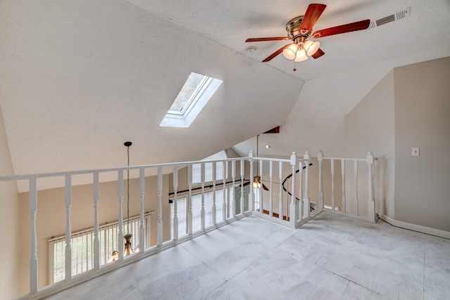 additional living space with a textured ceiling, ceiling fan, and vaulted ceiling