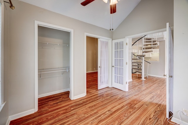 unfurnished bedroom featuring high vaulted ceiling, light wood-type flooring, and ceiling fan