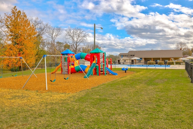 view of play area with a lawn and a pool