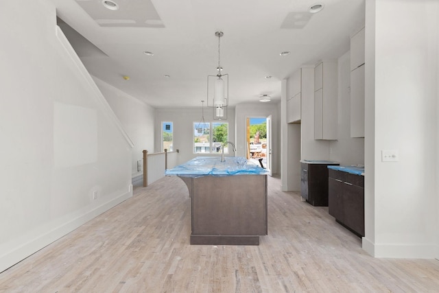 1016 W Trinity Ln Unit 18, Nashville, TN 37218 - kitchen featuring baseboards, an island with sink, light wood-style flooring, modern cabinets, and dark brown cabinets