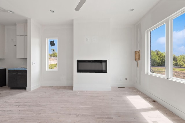 1016 W Trinity Ln Unit 18, Nashville, TN 37218 - unfurnished living room with a glass covered fireplace, light wood finished floors, baseboards, ceiling fan, and recessed lighting