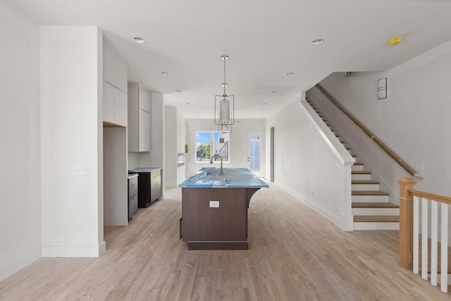 1016 W Trinity Ln Unit 18, Nashville, TN 37218 - kitchen with light wood-style floors, white cabinetry, a kitchen island with sink, baseboards, and recessed lighting