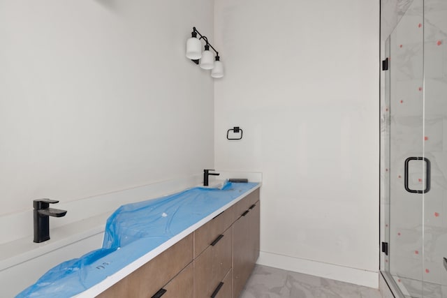 bathroom with a shower with shower door and vanity