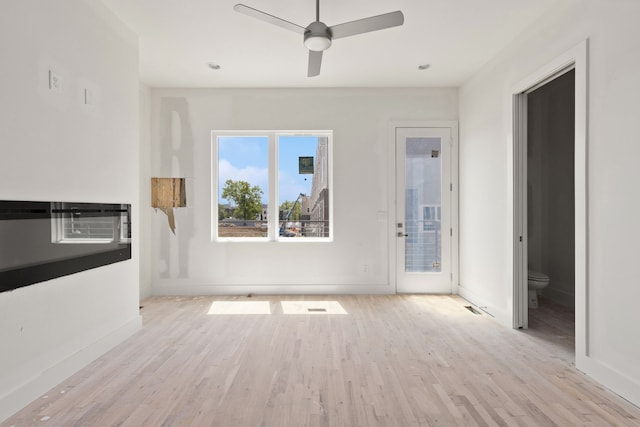 unfurnished living room featuring light wood-type flooring and ceiling fan