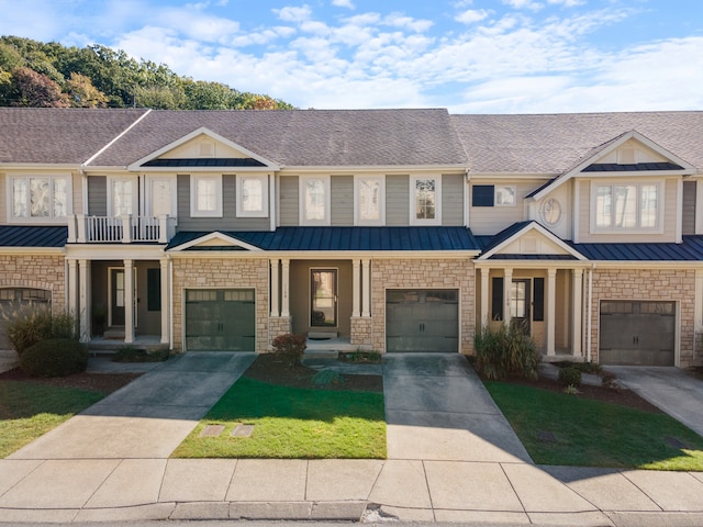 view of property with a garage, a front lawn, and a balcony