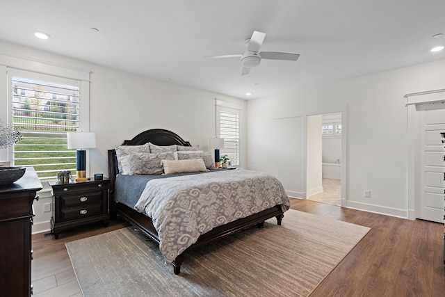 bedroom with hardwood / wood-style flooring, ceiling fan, and ensuite bath