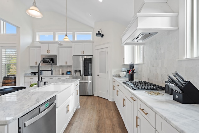 kitchen with white cabinets, a wealth of natural light, stainless steel appliances, and hanging light fixtures