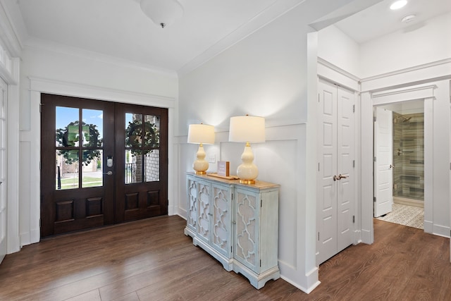 foyer entrance featuring french doors, dark hardwood / wood-style floors, and crown molding