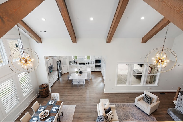 living room with dark wood-type flooring, beamed ceiling, and a notable chandelier